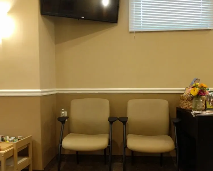 Seating and a television in the waiting room at Westfield Dental Associates.